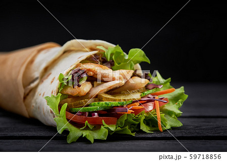 Tasty doner kebabs with fresh salad trimmings and shaved roasted meat served in tortilla wraps on 59718856