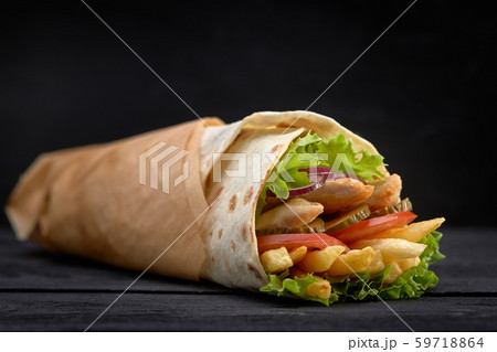 Tasty doner kebabs with fresh salad trimmings and shaved roasted meat served in tortilla wraps on 59718864