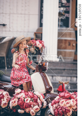 Adorable little girl in hat on the moped outdoors 59719550