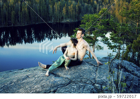 middle age man with little cute son doing sport yoga on the top of the mountain together, happy 59722017