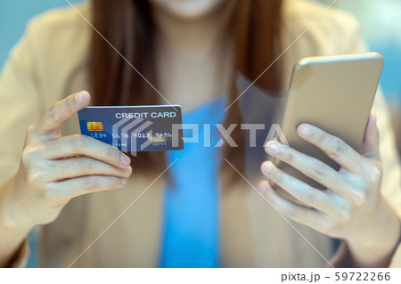 Closeup Asian woman using credit card with mobile for online shopping in department store over the clothes shop store background, technology money wallet and online payment concept, credit card mockup 59722266