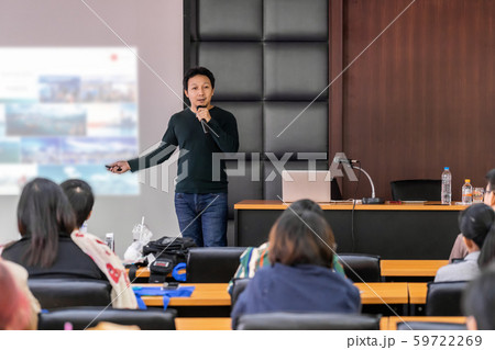 Asian Speaker or lecture with casual suit on the stage presenting via projector screen in the conference hall or seminar meeting room to Audience, business education and Seminar concept 59722269