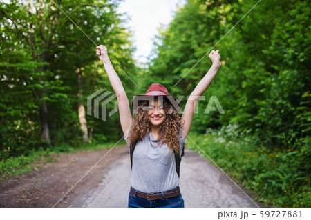 Young tourist woman traveller walking in nature, stretching arms. Young tourist woman traveller walking in nature, stretching arms. 59727881