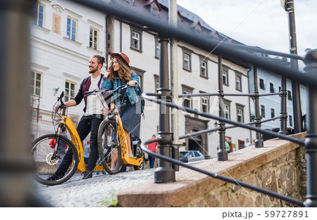 Young tourist couple travellers with electric scooters in small town. 59727891