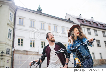 Young tourist couple travellers with electric scooters in small town. 59727894