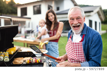 Portrait of multigeneration family outdoors on garden barbecue, grilling. 59727899