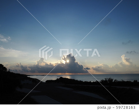 海の上、雲から顔を覗かせる夕陽 海の上、雲から顔を覗かせる夕陽 59728163