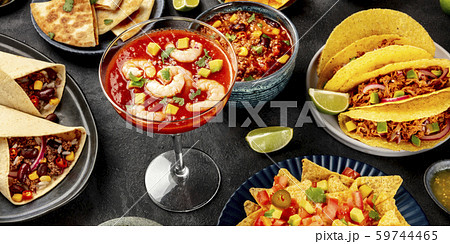 Mexican food panorama on a black background. Shrimp cocktail, chili con carne, tacos, and other 59744465