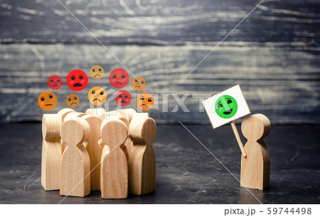 A man with a poster affects an annoyed crowd. Decrease in protest moods, reason and call for humility. Change the bad attitude. Phobias and stereotypes in society. Debunking fake news. Lead 59744498