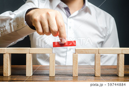 A man is completing the constructionA man is completing the construction of a bridge. Build bridges, make connections and useful contacts. Improving and developing a business. New innovat of a bridge. 59744884