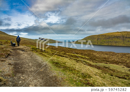 Unidentified tourists hikes in Sorvagsvatn lake over, Faroe Islands 59745282