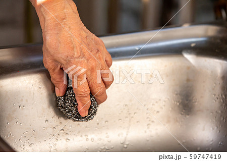 Senior Woman's left hand using steel wool for cleaning sink Close up shot, Selective focus, kitchen concept 59747419