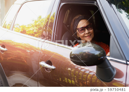 Happy senior woman in sunglasses driving a car. 59750481
