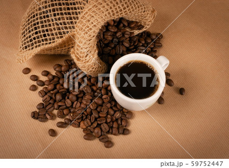Hot coffee cup and coffee beans on brown Hot coffee cup and coffee beans on brown 59752447