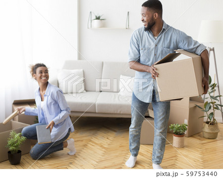 Cheerful Black Couple Unpacking Moving Boxes Indoor 59753440