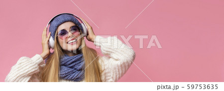 Cute winter girl enjoying music with modern wireless earphones Cute winter girl enjoying music with modern wireless earphones 59753635