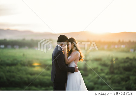 Sunshine portrait of happy bride and groom outdoor in nature location Sunshine portrait of happy bride and groom outdoor in nature location 59753718