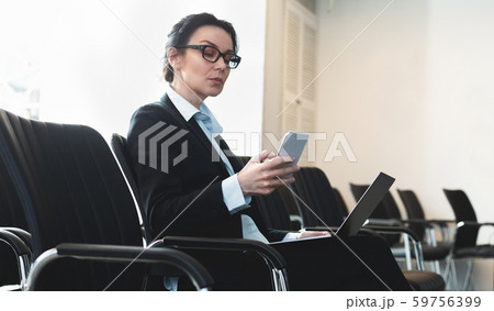 Businesswoman preparing for presentation, sitting in empty conference room Businesswoman preparing for presentation, sitting in empty conference room 59756399