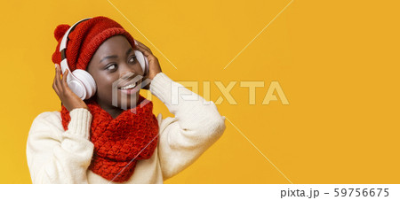 Interested black girl with headphones looking at empty space Interested black girl with headphones looking at empty space 59756675