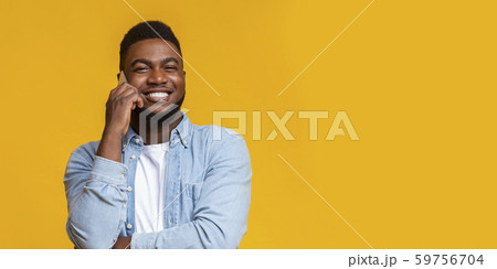 Smirking black man talking on cellphone and looking at camera 59756704