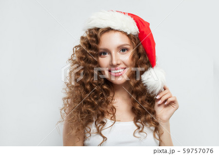 Happy young woman in Santa hat smiling on white Happy young woman in Santa hat smiling on white 59757076