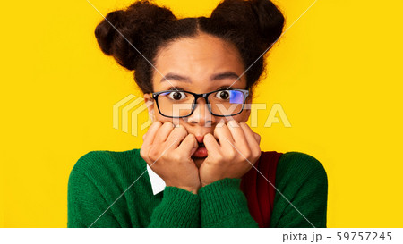 Portrait of afraid black teen looking shocked Portrait of afraid black teen looking shocked 59757245