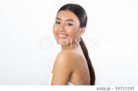 Body care. Young asian woman in bath towel smiling to camera Body care. Young asian woman in bath towel smiling to camera 59757295