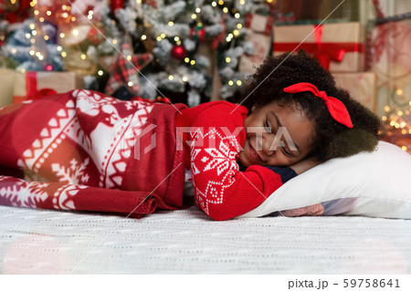 Adorable little black girl sleeping near christmas tree Adorable little black girl sleeping near christmas tree 59758641