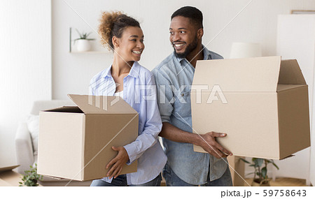 African American Spouses Carrying Moving Boxes Smiling Standing Back-To-Back Indoor African American Spouses Carrying Moving Boxes Smiling Standing Back-To-Back Indoor 59758643