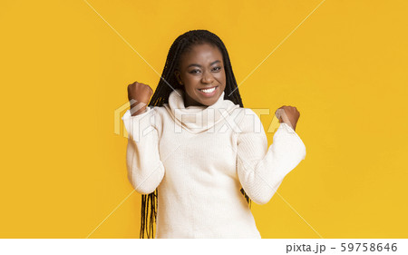 Emotional afro woman expressing happiness, clenching fists Emotional afro woman expressing happiness, clenching fists 59758646