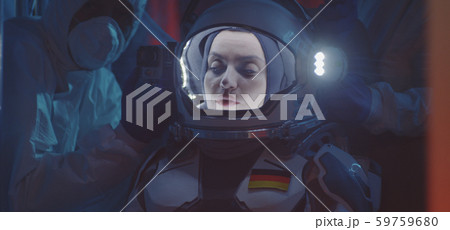 Scientist helping astronaut to put on spacesuit Scientist helping astronaut to put on spacesuit 59759680