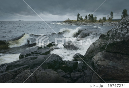 Waves of stormy sea break on rocky shore. Waves of stormy sea break on rocky shore. 59767274