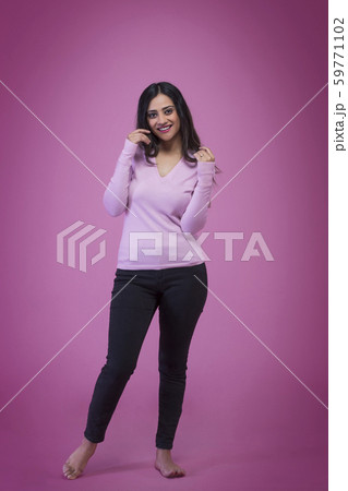 Portrait of a smiling young teenager in jeans standing and posing for photograph 59771102