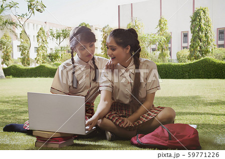 School girls studying on a laptop in the school campus garden School girls studying on a laptop in the school campus garden 59771226