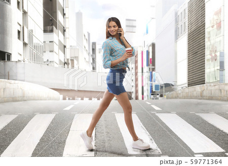 Young woman walking on zebra crossing 59771364
