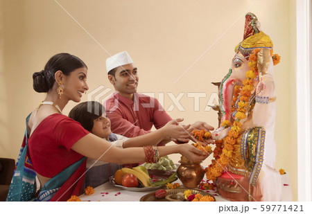 Family offering flowers to Ganpati Idol on Ganesh Chaturthi 59771421