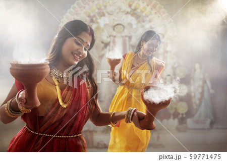 Two bengali women performing dhunuchi dance on the occasion of durga puja 59771475