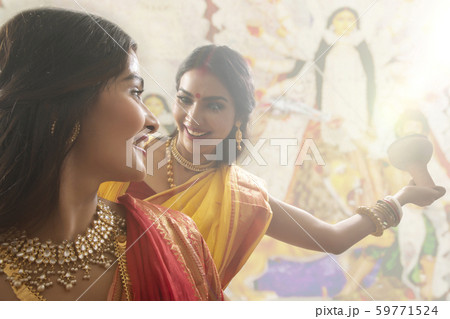 Two Married bengali women performing dhunuchi dance on the occasion of durga puja 59771524
