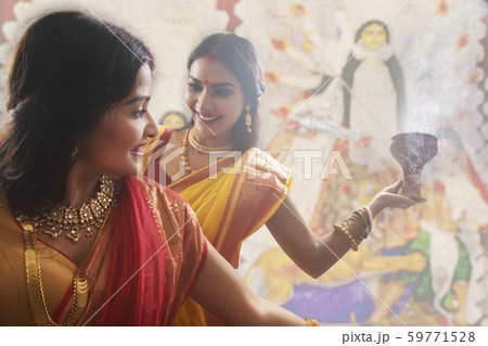 Two Married bengali women performing dhunuchi dance on the occasion of durga puja Two Married bengali women performing dhunuchi dance on the occasion of durga puja 59771528