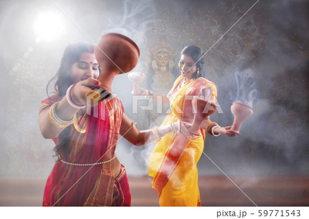 Two Married bengali women performing dhunuchi dance on the occasion of durga puja 59771543