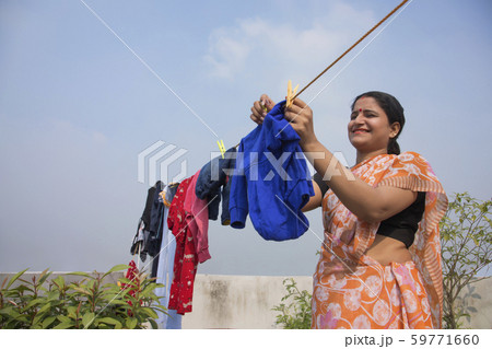 indian woman drying clothes on clothesline 59771660