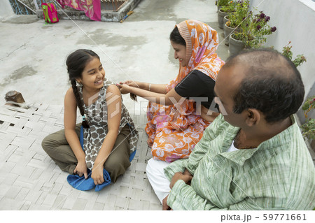 Portrait of happy Indian family sitting on a camp bed having fun 59771661