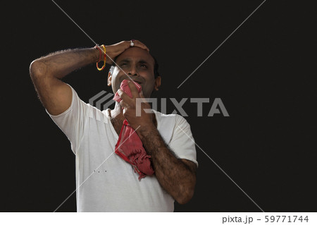 Depressed Indian farmer standing and holding his head in disbelief Depressed Indian farmer standing and holding his head in disbelief 59771744