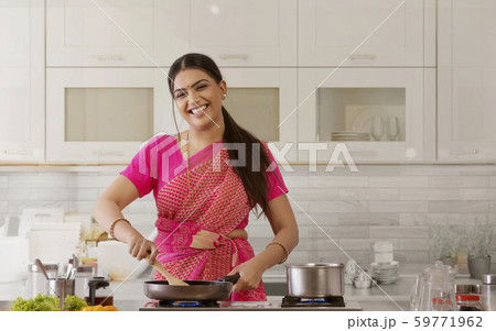 woman in saree cooking in the kitchen woman in saree cooking in the kitchen 59771962