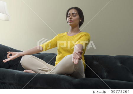 young woman sitting on the sofa with her eyes closed 59772264