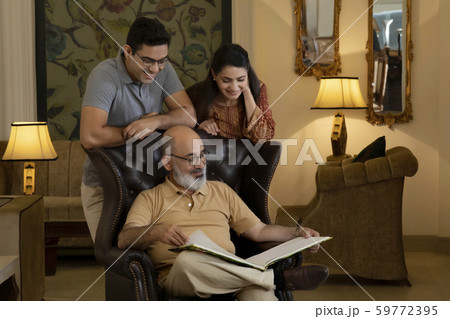 Father, mother and son are looking at a book. (Family) 59772395