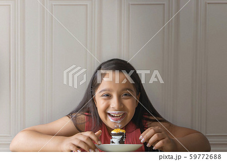 Smiling girl with milk moustache eating a stack of cream biscuit pie Smiling girl with milk moustache eating a stack of cream biscuit pie 59772688