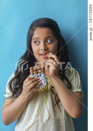 Girl eating chocolate looking away 59772689