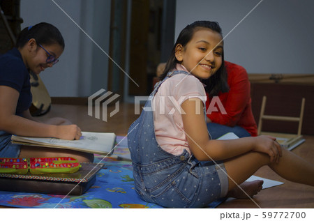 Mother and daughters sitting on floor sketching and colouring 59772700