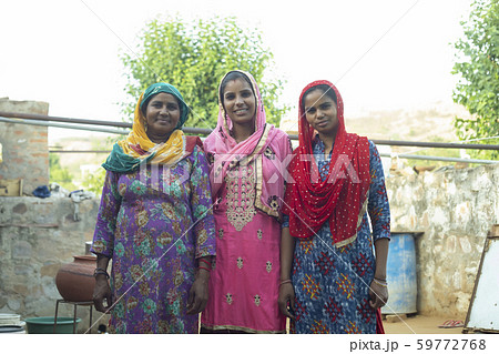 woman with her daughter and daughter-in-law standing in the court yard woman with her daughter and daughter-in-law standing in the court yard 59772768